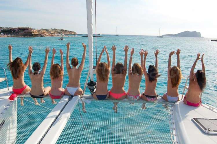 Boy-sunbathing-on-a-net-catamaran-Ibiza