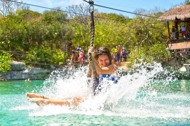 Girl-making-a-water-landing-from-a-zip-line-at-Xel-Há